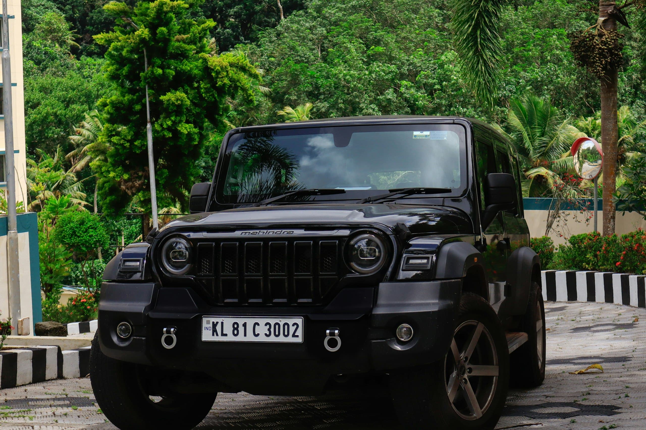 A black Mahindra Thar with custom wheels and bumper